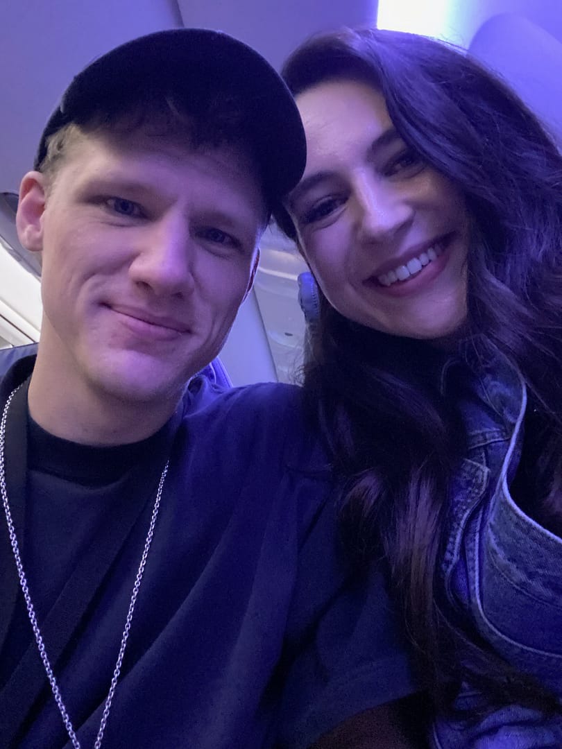 Dina and Scott in an airplane on their way to enjoy their London vacation.