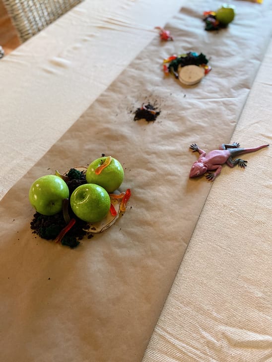 up close critter table decorations with apples, gummy worms, crushed oroes, and edible moss