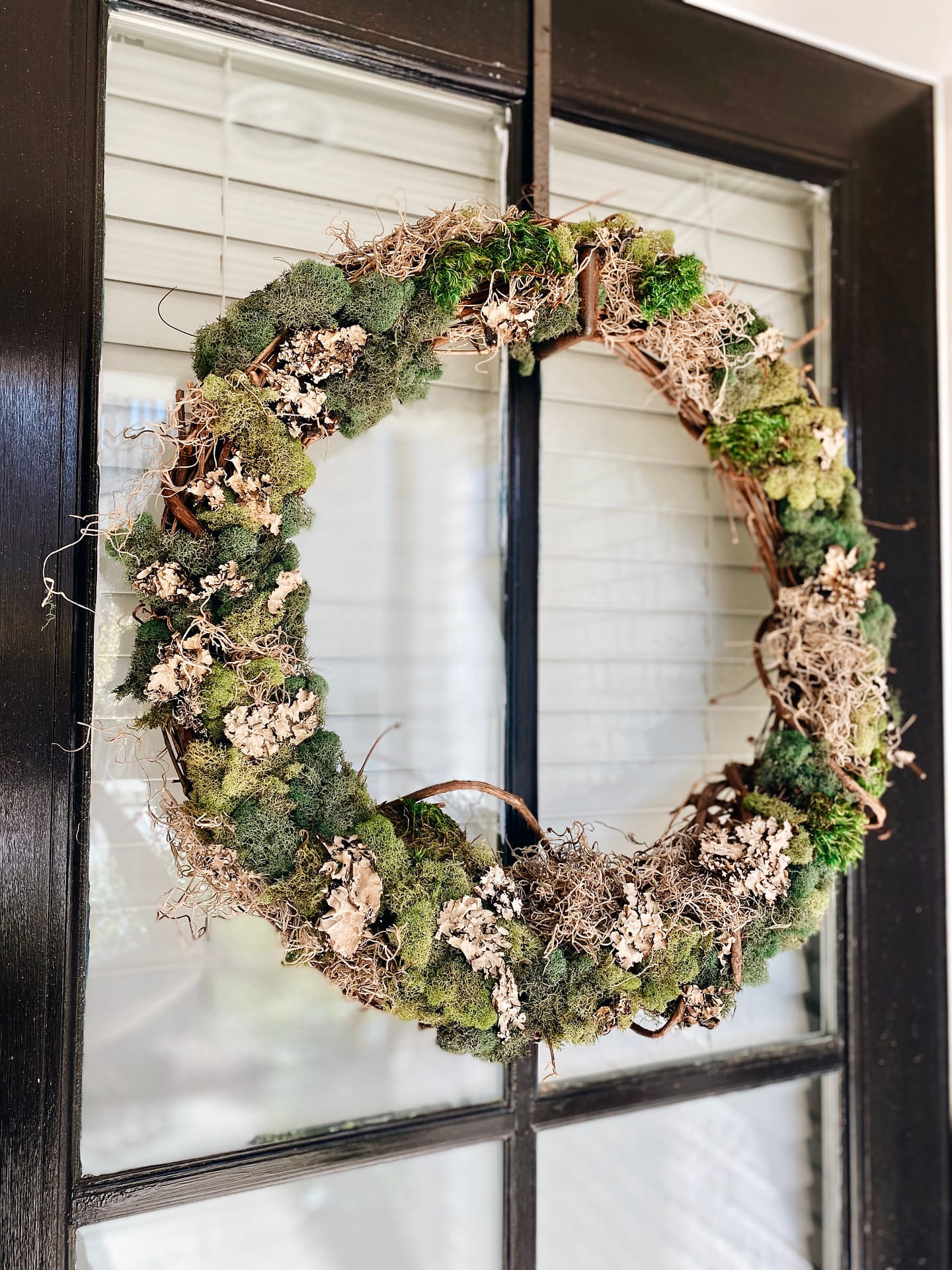 moss door wreath hanging on door
